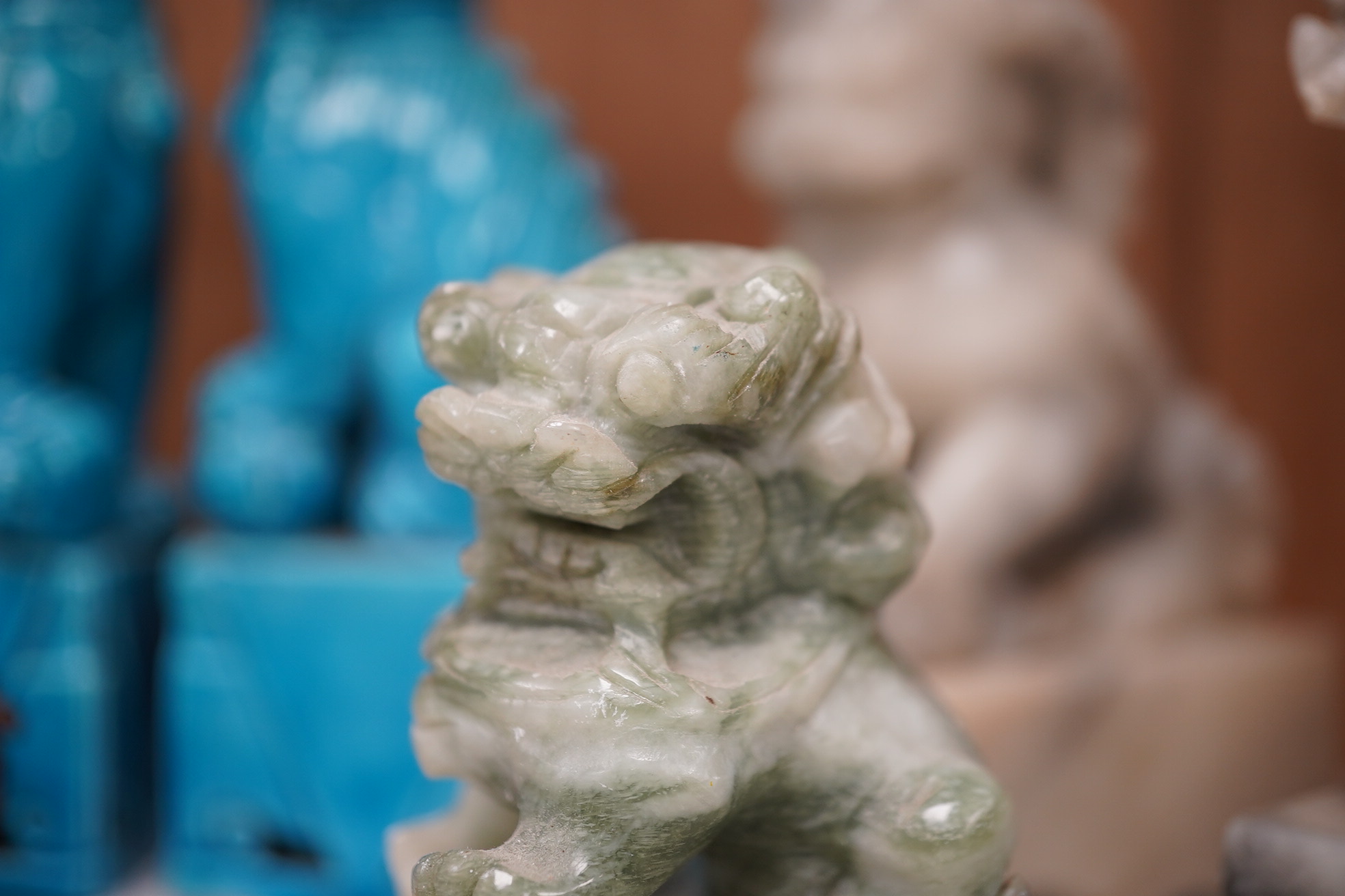 A group of Chinese items; a pair of turquoise glazed ceramic lion dogs, two pairs of soapstone carvings, various ‘dragon’ carvings etc. Condition - fair to good